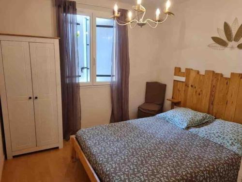 une chambre avec un lit, une fenêtre et un lustre dans l'établissement Maison*Piscine chauffée*SPA, à Saint-Martial-de-Nabirat