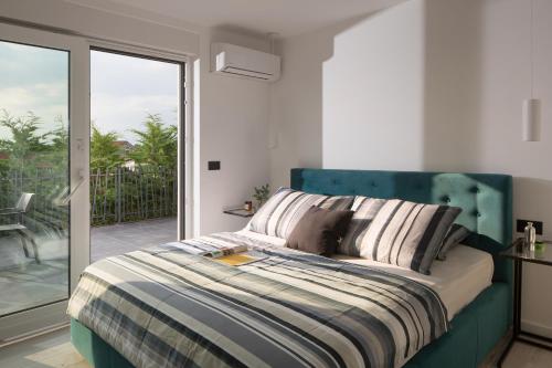 1 dormitorio con 1 cama con cabecero azul en Modern villa Dea with jacuzzi and pool in Porec, en Flengi