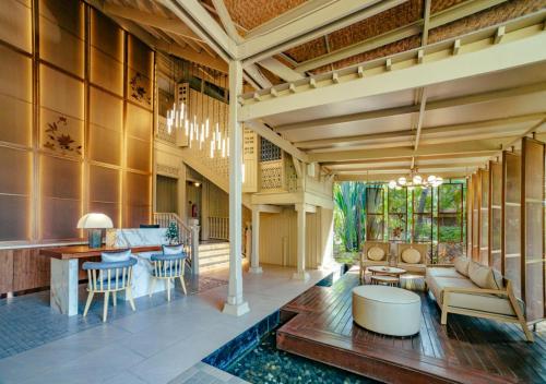 an open living room with a table and a couch at Pelangi Beach Resort & Spa, Langkawi in Pantai Cenang