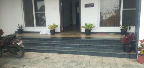 a house with potted plants on the front porch at HillTop in greany meadows yercaud in Yercaud