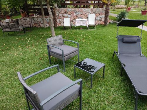 a group of chairs and tables in the grass at Nikos Apartments in Ormos Panagias