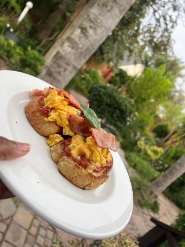 a white plate with a breakfast sandwich on it at Sir Roys Guest House in Port Elizabeth
