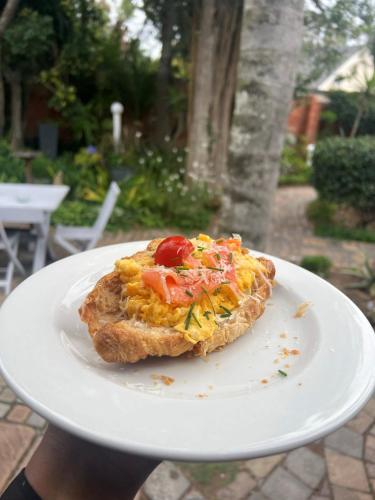 a white plate with a piece of food on it at Sir Roys Guest House in Port Elizabeth