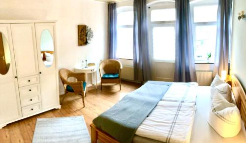 Schlafzimmer mit einem Bett, einem Schreibtisch und Fenstern in der Unterkunft Sonnenhof Bad Schandau in Bad Schandau
