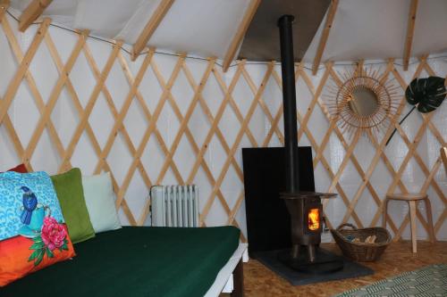 a room with a stove and a bed in a tent at Le Nid du Tui in Faverolles