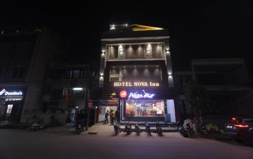 a hotel room inn with benches in front of it at night at Hotel Nova Inn by StayApart in Bulandshahr