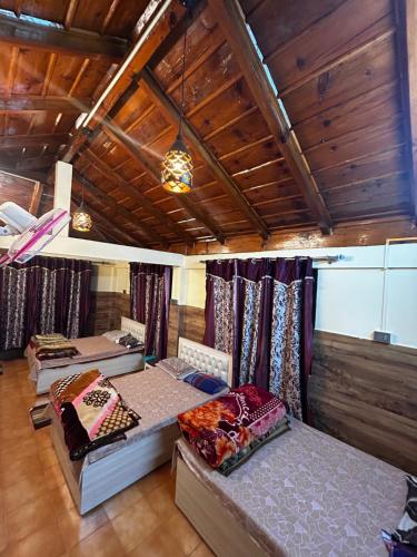 - une chambre avec 4 lits dans une chambre dotée de plafonds en bois dans l'établissement Kirola hotels, à Rāmgarh