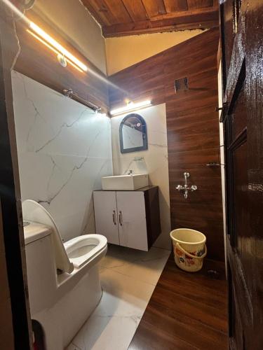 La petite salle de bains est pourvue de toilettes et d'un lavabo. dans l'établissement Kirola hotels, à Rāmgarh