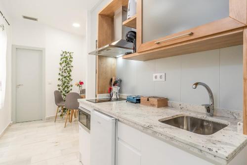 una cucina con mobili bianchi e un lavandino di GRX Gran vía Catedral a Granada