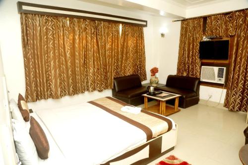 a hotel room with a bed and a couch and chair at Hotel India international Deluxe in New Delhi