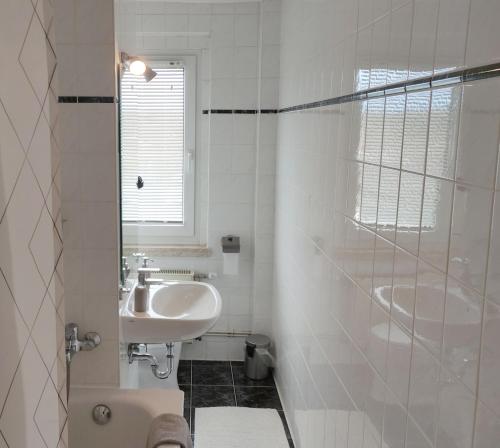 y baño blanco con lavabo y ducha. en Apartment E - feel good, en Leipzig