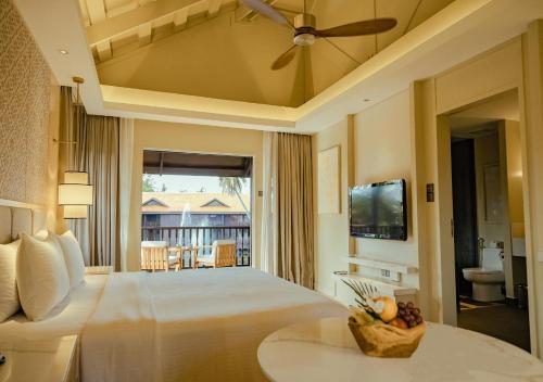 a bedroom with a large bed with a ceiling fan at Pelangi Beach Resort & Spa, Langkawi in Pantai Cenang