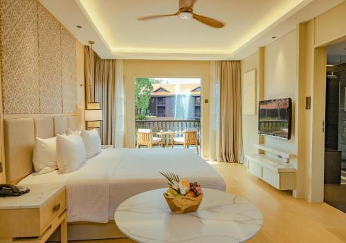 a bedroom with a bed and a table with a bowl of fruit on it at Pelangi Beach Resort & Spa, Langkawi in Pantai Cenang