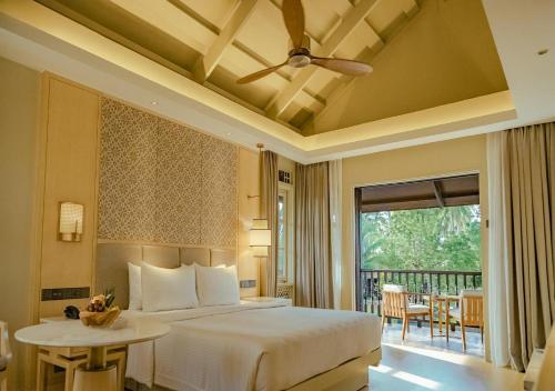 a bedroom with a bed and a balcony at Pelangi Beach Resort & Spa, Langkawi in Pantai Cenang