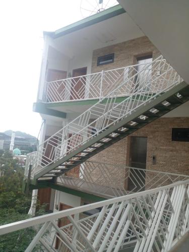 a white staircase on the side of a building at Triple 8 Suites in Labuan Bajo
