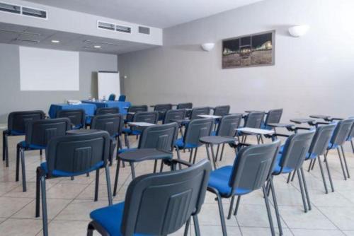 a room full of chairs and tables with blue chairs at Blu Hotel - Sure Hotel Collection by Best Western in Collegno