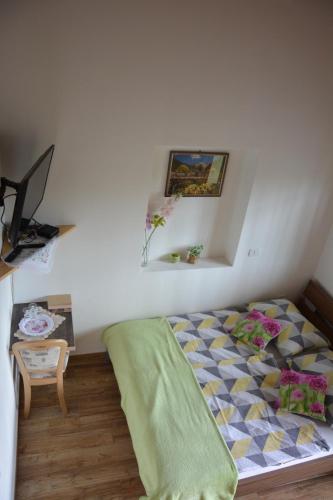 a small bedroom with a bed and a table at Apartmaji Kobal in Zoll