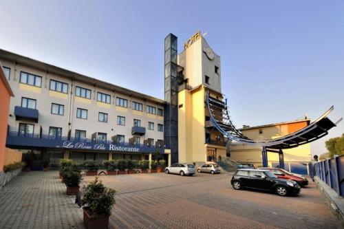 a large building with cars parked in a parking lot at Blu Hotel - Sure Hotel Collection by Best Western in Collegno