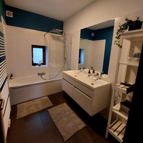 a bathroom with a tub and a sink and a bath tub at Au Cerf & Fagnes in Spa