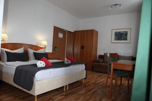 a bedroom with a bed and a desk and a table at Hotel Alt-Erfurt in Erfurt