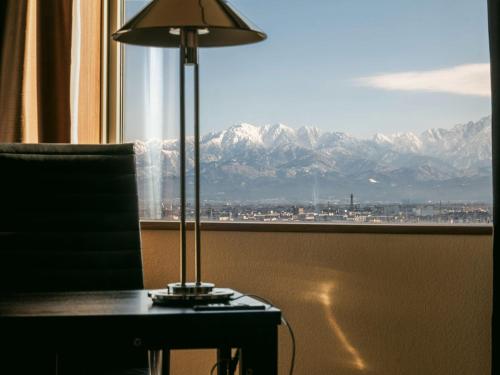 富山的住宿－富山奧克斯運河公園酒店，坐在窗前桌子上的一盏灯