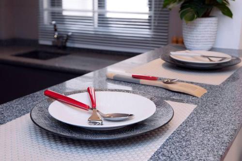 a table with plates and spoons on a counter at Harmony Villa in Tema
