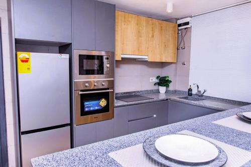 a kitchen with a refrigerator and a stove top oven at Harmony Villa in Tema