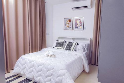 a bedroom with a white bed with a dog laying on it at Harmony Villa in Tema