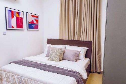 a bed with white sheets and pillows in a bedroom at Harmony Villa in Tema