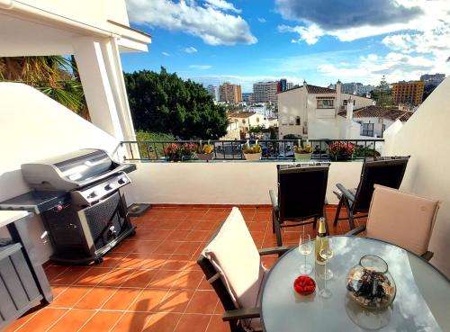 a patio with a table and a grill on a balcony at Estudio PasoDoble. Pueblo Evita in Benalmádena