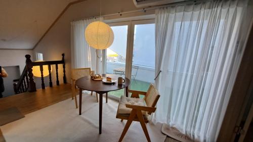 a dining room with a table and a large window at Soban Stay in Busan
