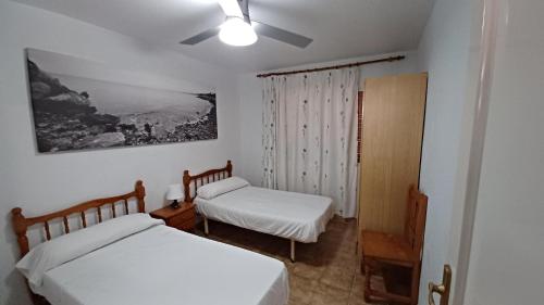 a bedroom with two beds and a ceiling fan at Adosado Puntamer Orangecosta in Peñíscola