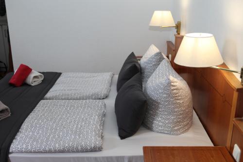 a bedroom with two beds with pillows and a lamp at Hotel Alt-Erfurt in Erfurt