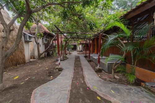 a walkway in front of a house with trees at Omah Gili Hotel in Gili Air