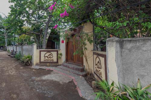 a building with a wooden door on a street at Omah Gili Hotel in Gili Air