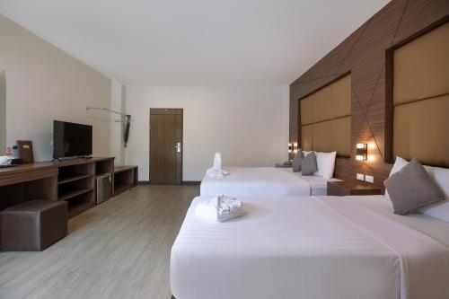 a hotel room with two beds and a flat screen tv at The Bell Airport Phuket Hotel - SHA Extra Plus in Nai Yang Beach