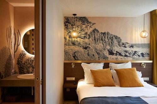 een hotelkamer met een bed en een wastafel bij HOTEL LA MARINE in Groix