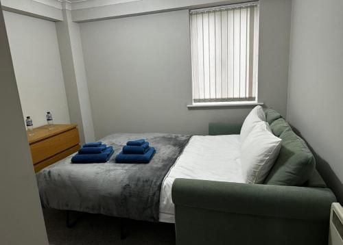 a bedroom with a bed with blue pillows on it at Two bedroom modern flat near central London in London