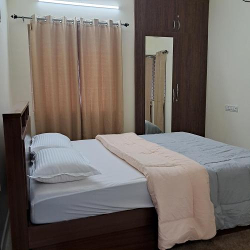 Un pat sau paturi într-o cameră la Yazh Vedha Homes