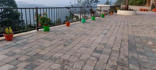 a patio with potted plants and a fence at HillTop in green meadows yercaud in Yercaud