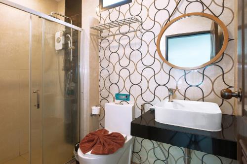 a bathroom with a sink and a mirror and a toilet at The Bell Airport Phuket Hotel - SHA Extra Plus in Nai Yang Beach