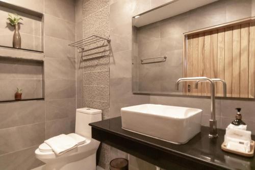 y baño con lavabo y aseo. en Ananzitra Hotel en Kanchanaburi