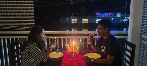 un homme et une femme assis à une table avec un gâteau d'anniversaire dans l'établissement Evaan's Casa Homestay, à Alappuzha