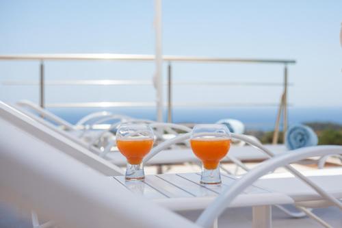 two glasses of orange juice sitting on a table on a boat at Francis & Gregorys Luxury Villas in Afantou