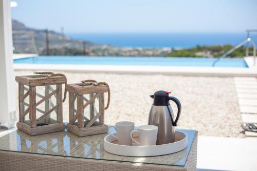 a tray with a coffee pot and cups on a table at Francis & Gregorys Luxury Villas in Afantou