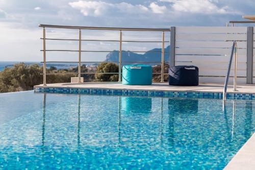 a swimming pool with blue water in front of a building at Francis & Gregorys Luxury Villas in Afantou