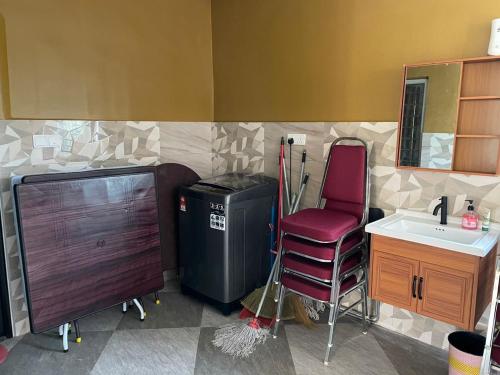 a bathroom with a trash can and a chair and a sink at Sepang Putra Bagan Lalang Semi D House in Sungai Pelik