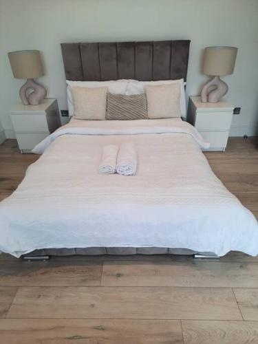a bedroom with a large bed with two towels on it at Luxury Kingsize Room in London in Catford