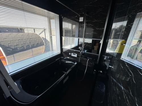 a bath tub in a room with a window at The No.10 Sunrise Beach 九十九里 in Kujukuri