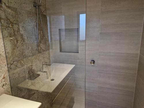 a bathroom with a shower with a sink and a toilet at Cosy Secure comfortable for two in Canberra in Hall